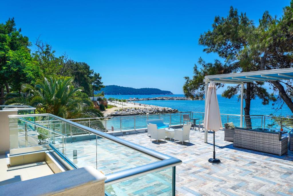 a patio with chairs and an umbrella and the water at Studios Nautilus in Potos