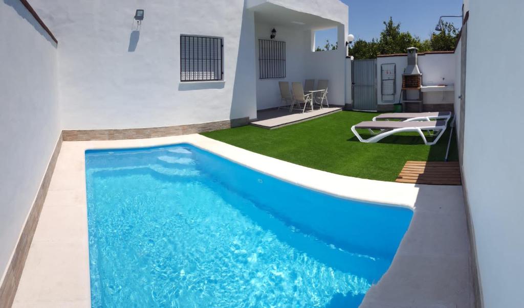 uma piscina com água azul num quintal em Casa Los Naranjos 3 em Cádiz