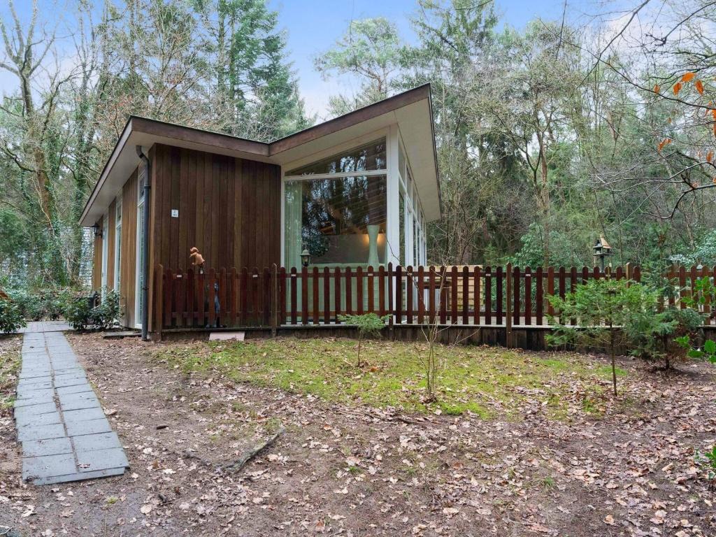 uma pequena casa com uma cerca de madeira num quintal em Idyllically located Holiday Home in Norg with Sauna em Norg