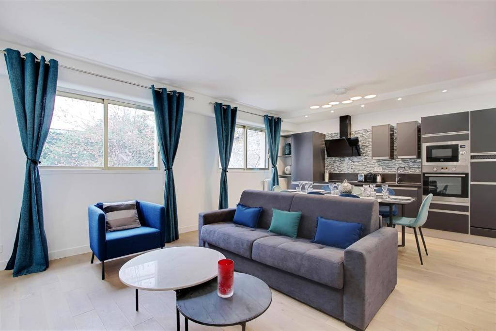 ein Wohnzimmer mit einem Sofa und einem Tisch in der Unterkunft TROCADERO/ EIFFEL TOWER - 3 Bedrooms- All New! in Paris