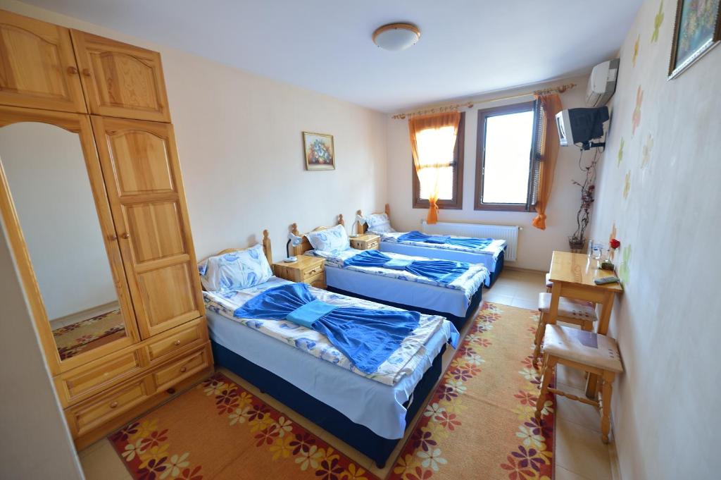 a room with three beds and a door at Family Hotel Varusha in Veliko Tŭrnovo