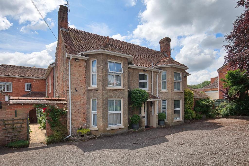 a large brick house with a driveway in front of it at The Old House Guest House in Salisbury