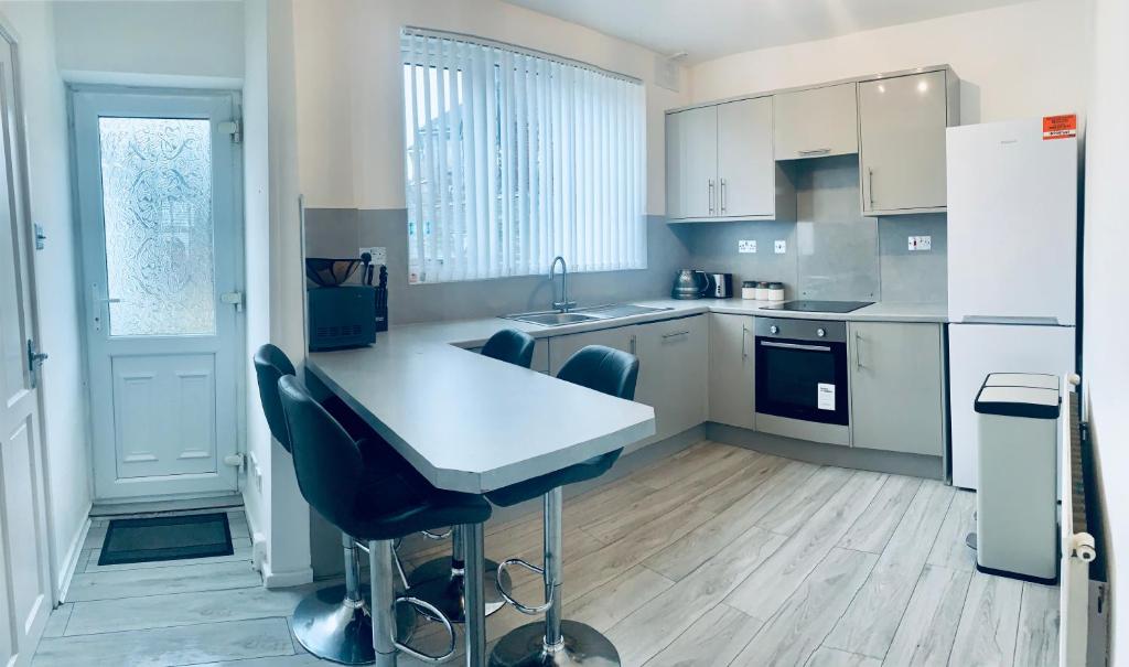 een keuken met een tafel en stoelen en een koelkast bij Stunning 3 bed residential home in Sheffield in Sheffield