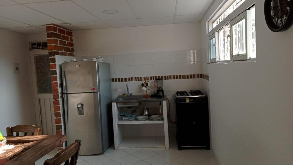 a small kitchen with a refrigerator and a sink at Apartamento Amoblado en Ibagué in Ibagué