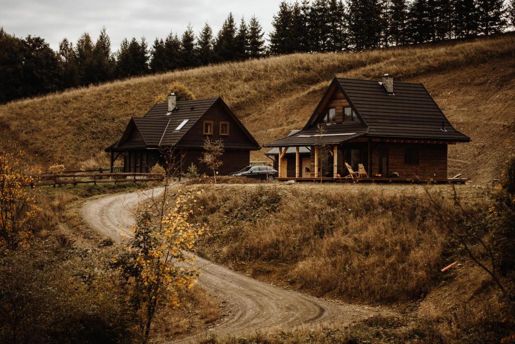 two houses on a hill next to a dirt road at Chata Sękata in Baligród