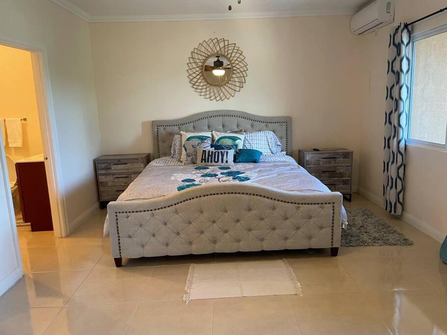 Schlafzimmer mit einem Bett und einem Wandspiegel in der Unterkunft My Palm Retreat in Mammee Bay