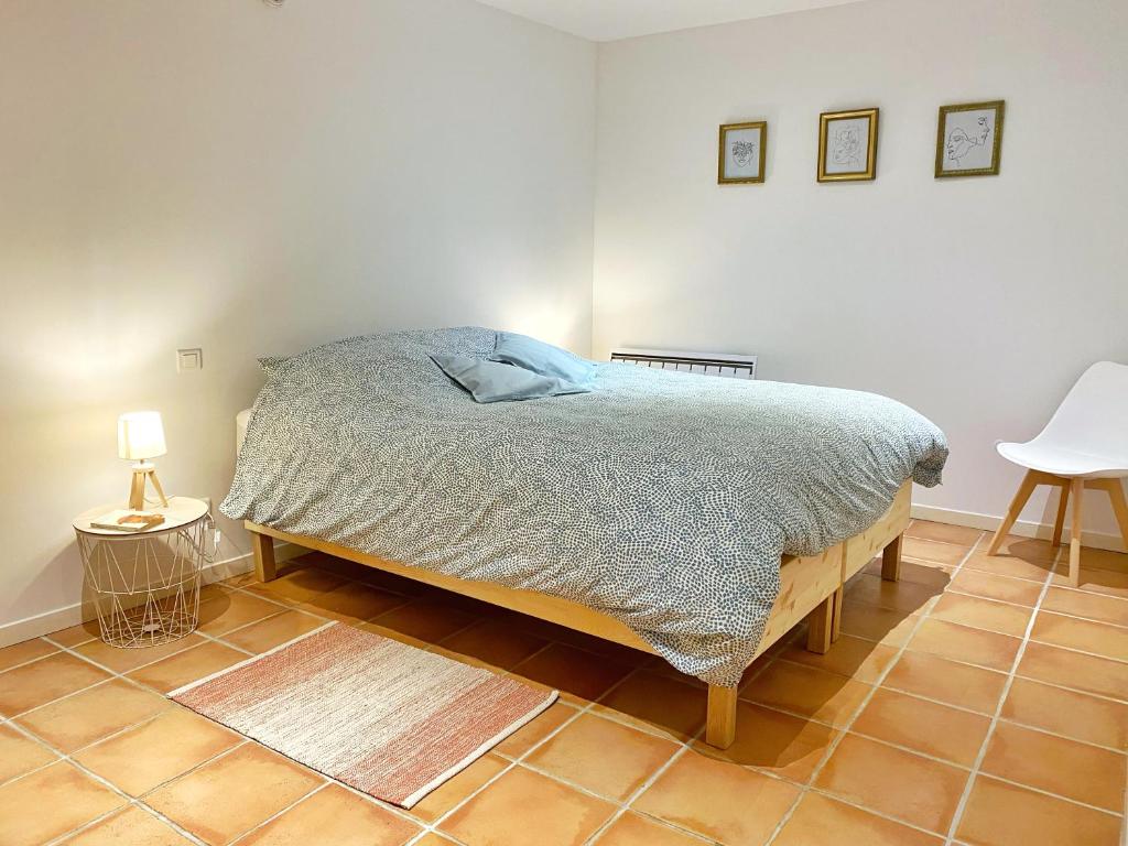 una camera da letto con un letto e un pavimento piastrellato di Appartements cocons dans les Corbières a Villesèque-des-Corbières
