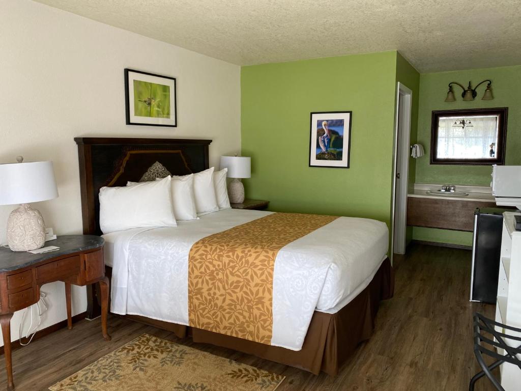 a hotel room with a large bed and a bathroom at La Kris Inn in Bandon