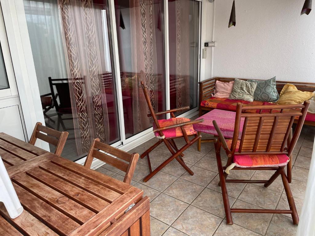 une chambre avec des chaises et un canapé sur un balcon dans l'établissement Villa Naturiste Port Nature, au Cap d'Agde
