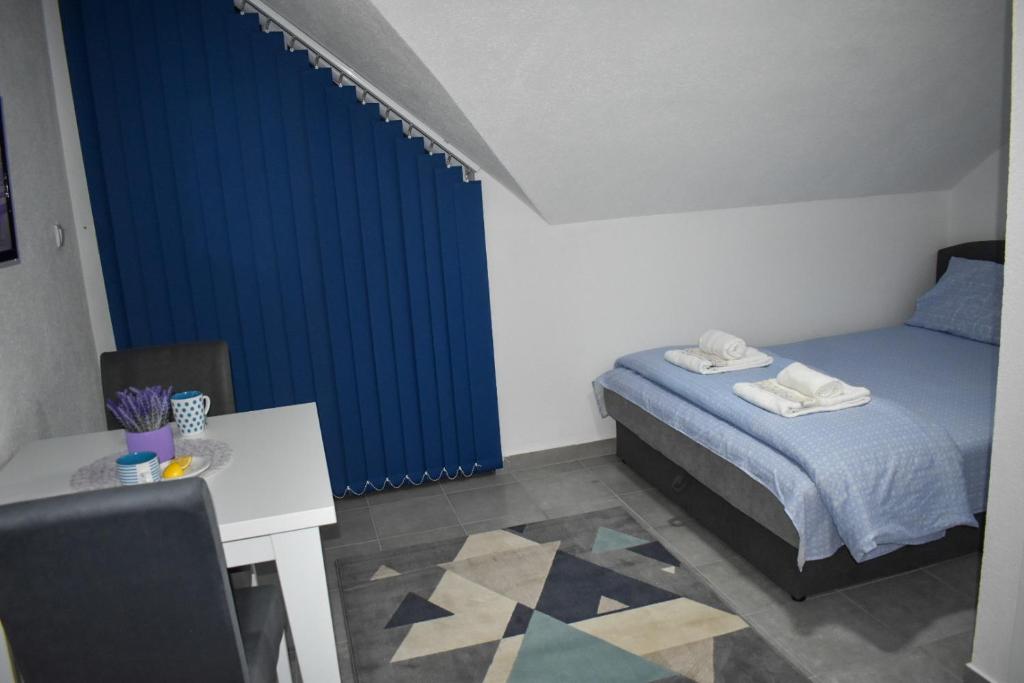 ein Schlafzimmer mit einem Bett und einem blauen Vorhang in der Unterkunft Šepački Most, Banja Koviljača, Loznica in Loznica