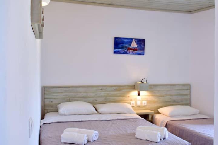 um quarto com 2 camas e toalhas em Meltemi apartment by opus em Agios Stefanos