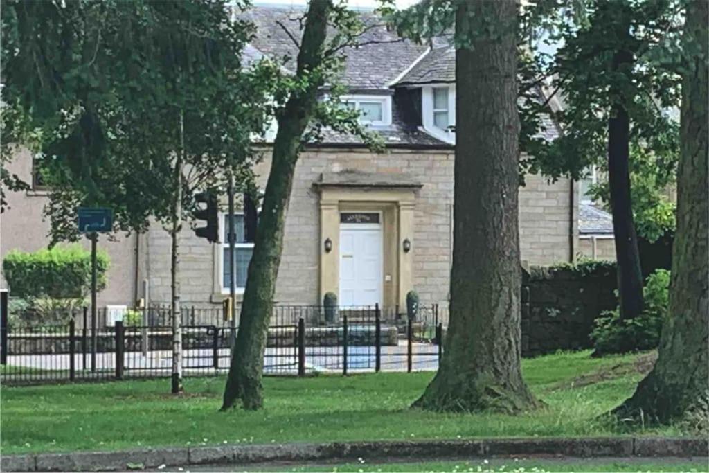 uma casa com uma porta branca e algumas árvores em Allerton - Victorian Character Home in Stirling em Stirling