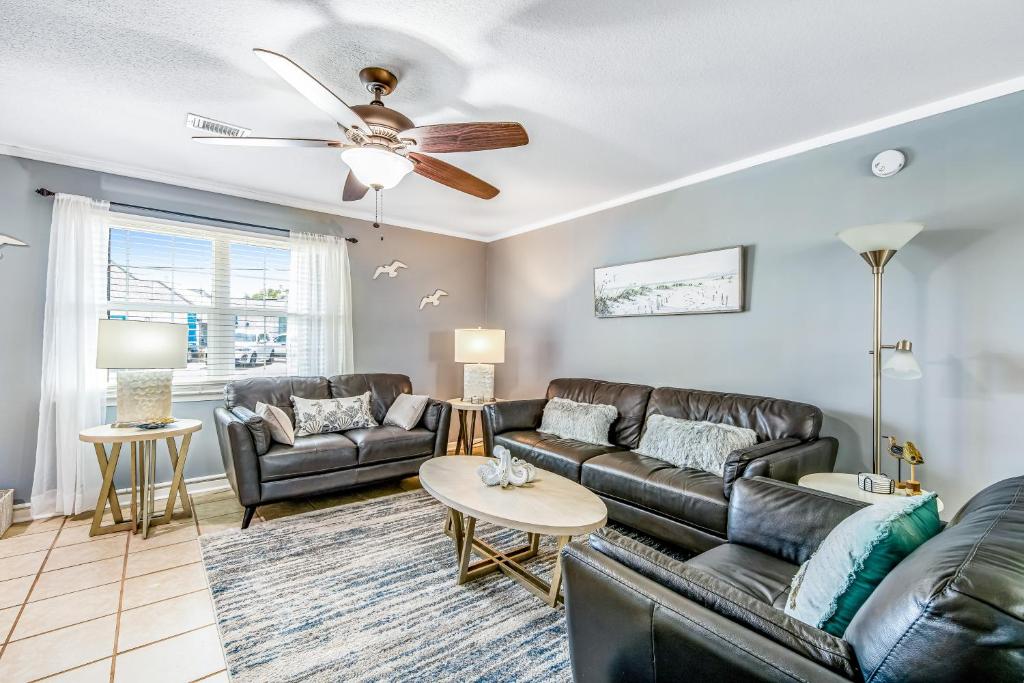 a living room with couches and a ceiling fan at Woodland Shores in Destin
