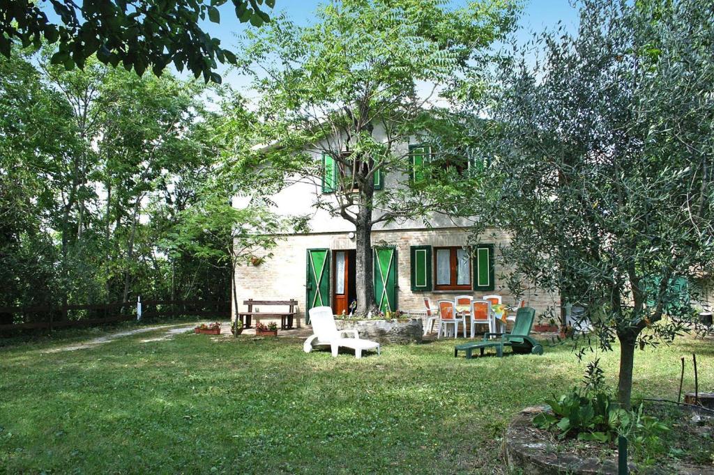een huis met stoelen en een tafel in de tuin bij Holiday home dei Pavoni, Montemaggiore in Montemaggiore al Metauro