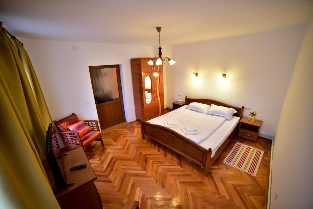 1 dormitorio con 1 cama y suelo de madera en Thalia Apartment en Sibiu