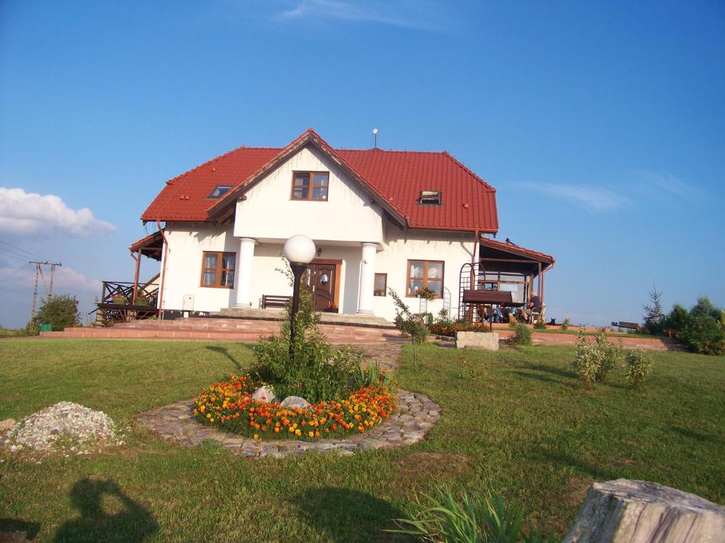 uma grande casa branca com um telhado vermelho em Agroturystyka na Górce em Nowa Wies