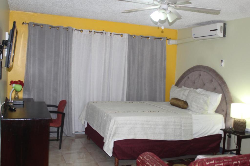 sypialnia z łóżkiem i wentylatorem sufitowym w obiekcie Comfy, Central & Elegant Studio New Kingston w mieście Kingston
