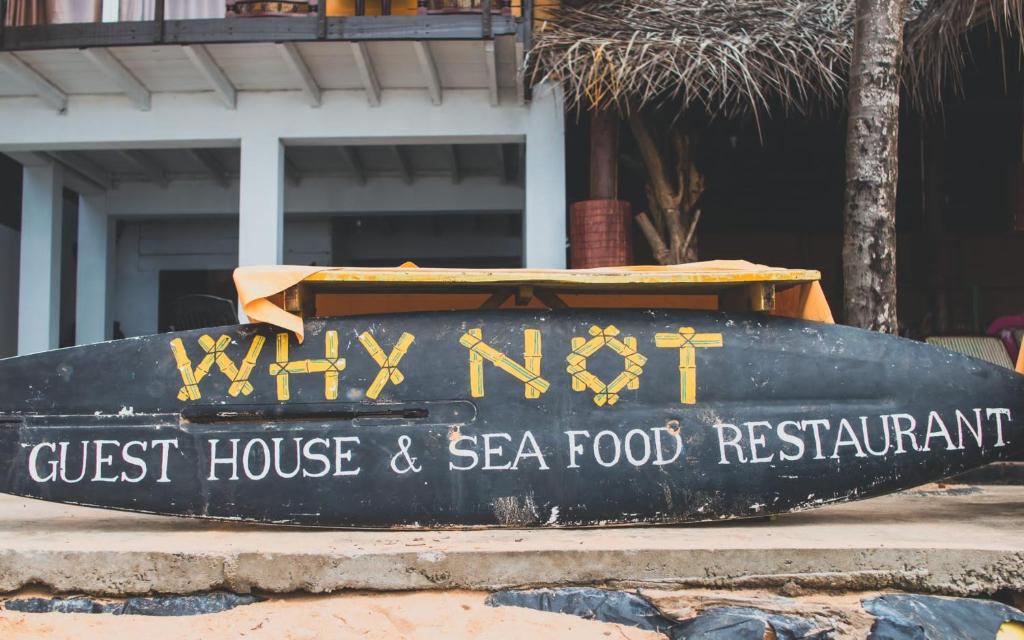 a sign for a guest house and sea food restaurant at Why Not Guest house in Hikkaduwa