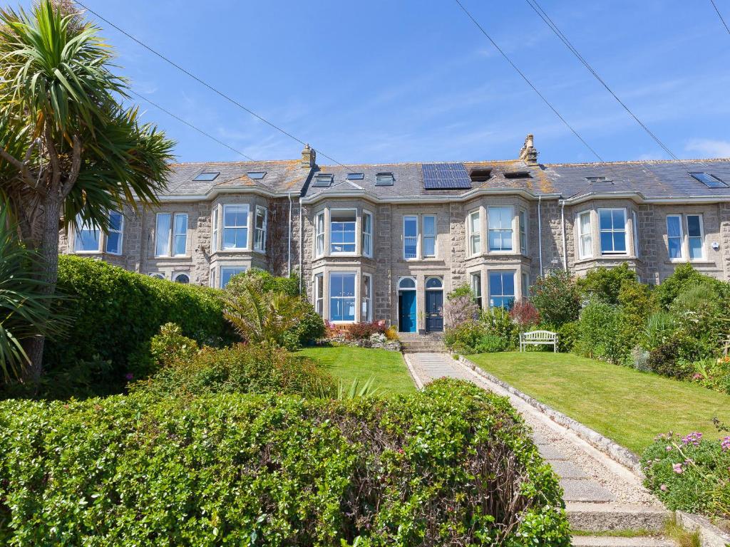 una casa grande con una palmera delante de ella en 6 Albany Terrace, en St Ives