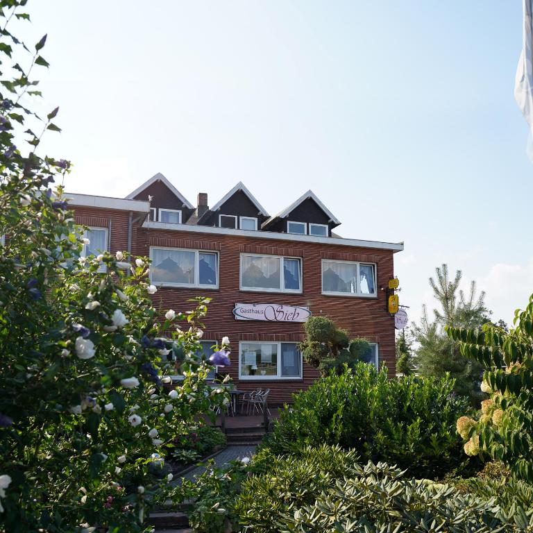 a building with bushes in front of it at Gasthaus Heiko Sieb in Wischhafen