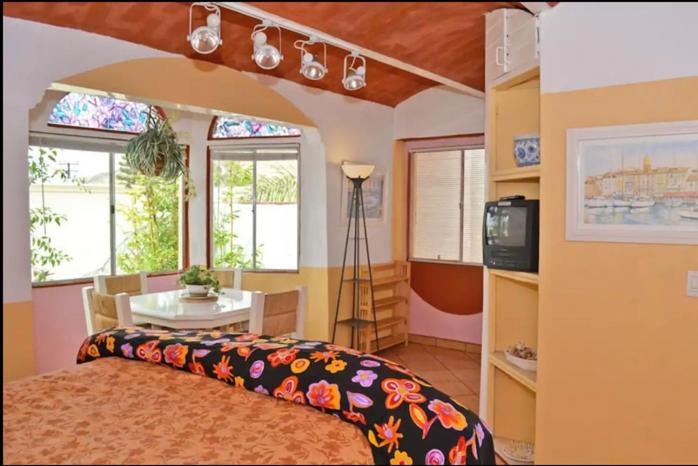 een slaapkamer met een bed en een tafel en ramen bij Welcome to Casa Viva Mexico 3-bedrooms 2-bathroms 6-Guests close to Shoping Center & Beach in Tijuana