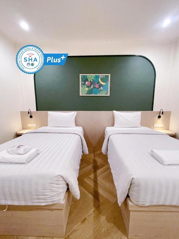 two beds in a hotel room with white sheets at Sky View Resort Buriram in Buriram