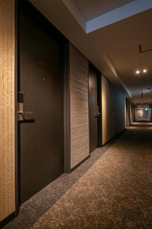 an empty corridor of a building with doors and carpet at Hotel Kanazawa in Kanazawa