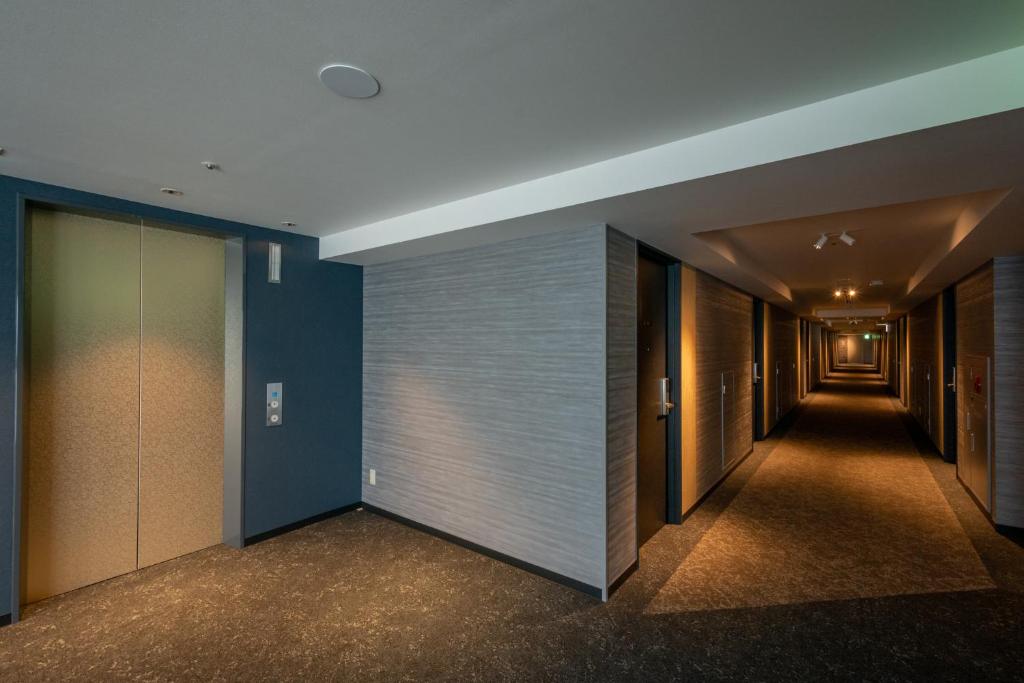 a hallway in a building with blue walls at Hotel Kanazawa in Kanazawa