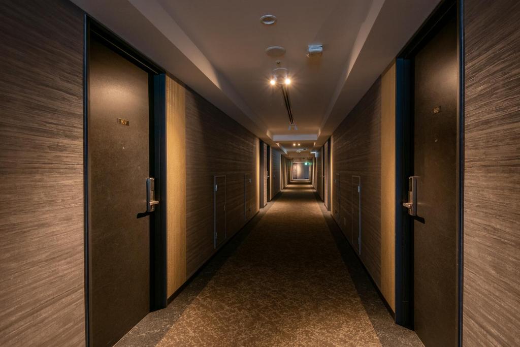 a corridor in a building with wooden walls and doors at Hotel Kanazawa in Kanazawa