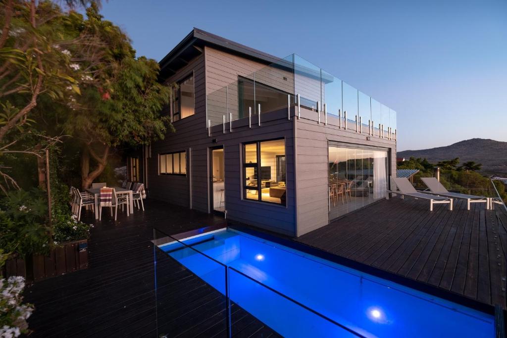 ein Haus mit einem blauen Pool davor in der Unterkunft Namaste Cape Point in Kapstadt