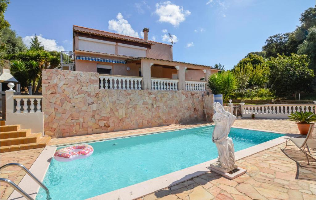 une statue en face d'une maison avec piscine dans l'établissement Lovely Apartment In Bastelicaccia With Wifi, à Bastelicaccia