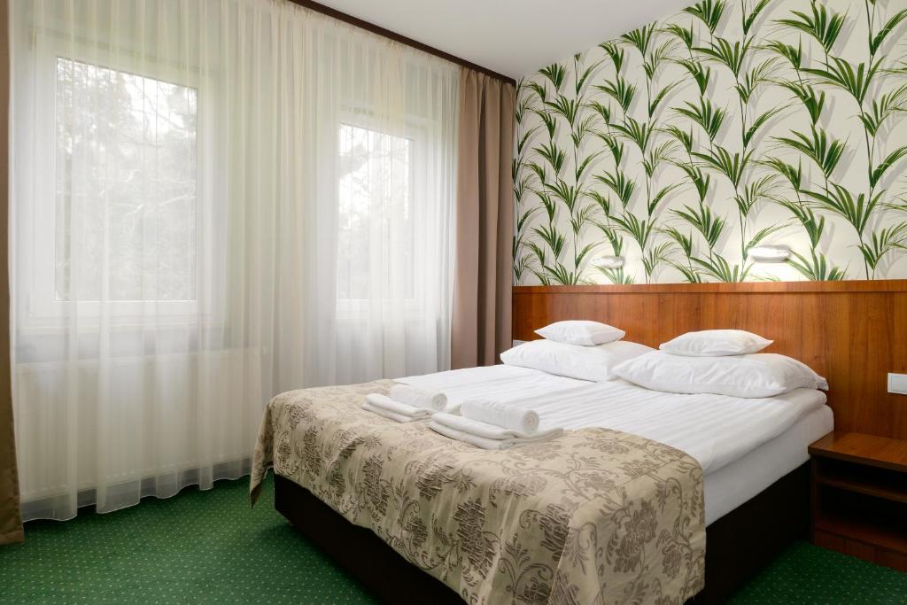 a bedroom with a large bed with a floral wall at Hotel Zielony in Poznań