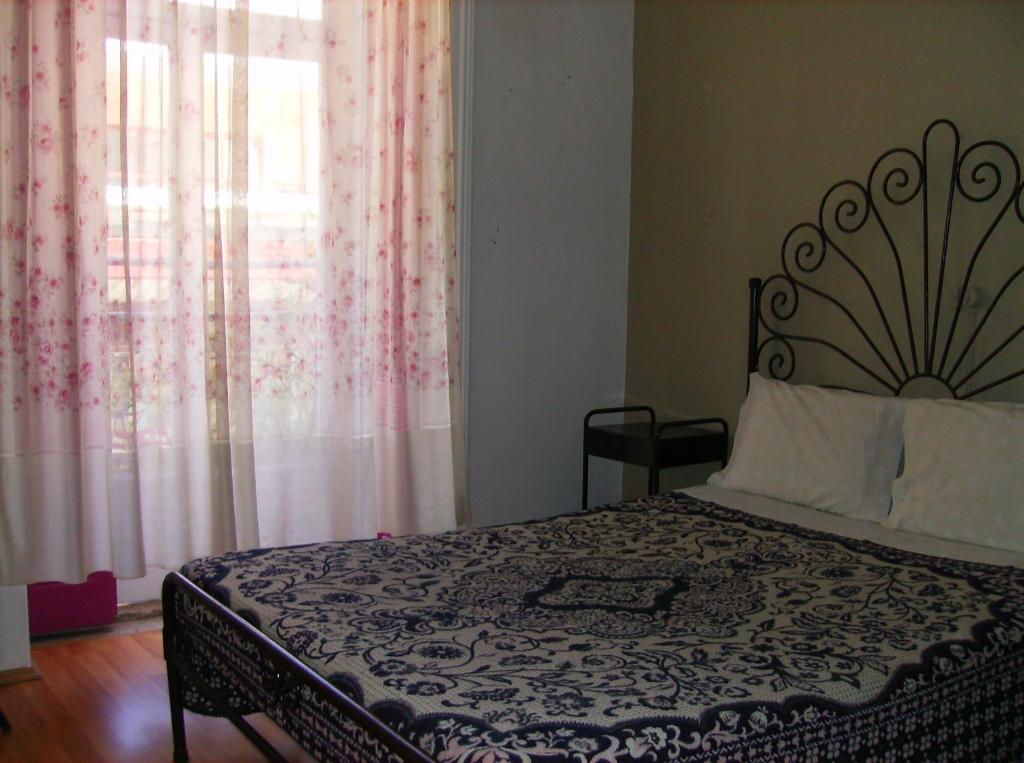 Schlafzimmer mit einem Bett und einem Fenster mit Vorhängen in der Unterkunft Dias e Dominguez in Lissabon