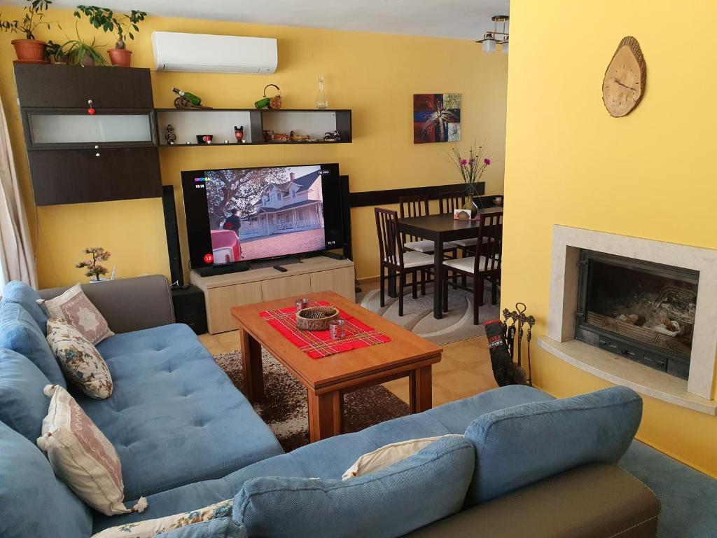 ein Wohnzimmer mit einem blauen Sofa und einem TV in der Unterkunft Koko's apartments 2 in Bansko