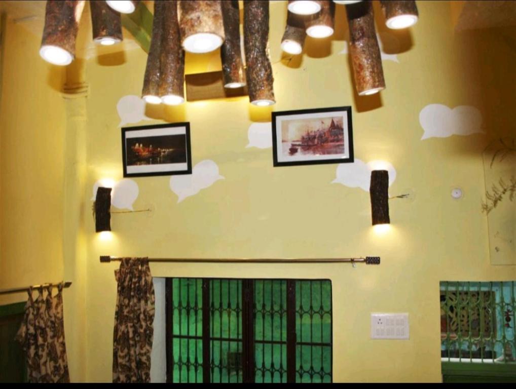 een muur met foto's van wolken en lichten erop bij MONALISA HOSTEL in Varanasi