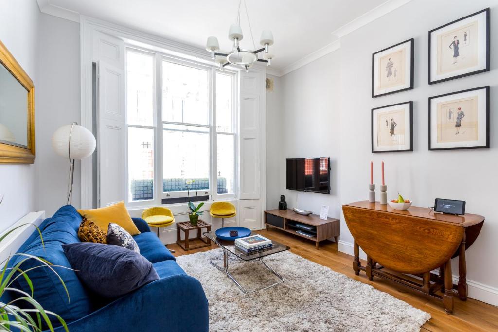 ロンドンにあるDear Newton One Bedroom in Notting Hillのリビングルーム(青いソファ、テーブル付)