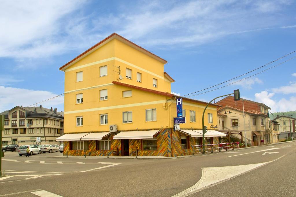 um edifício amarelo no lado de uma rua em Hosteria El Capricho em Vioño