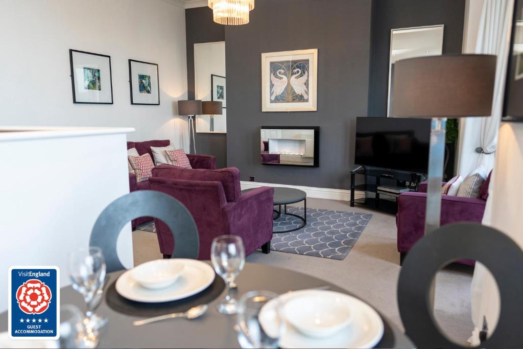 uma sala de estar com uma mesa com copos de vinho em The Helaina Apartments em Scarborough