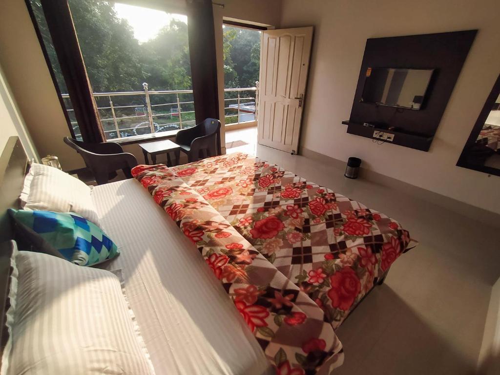 um quarto com uma cama com uma colcha em Anugraha Homestay em Ramnagar