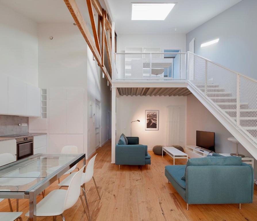ein Wohnzimmer mit einem Glastisch und einer Treppe in der Unterkunft AV Gijón Caveda in Gijón