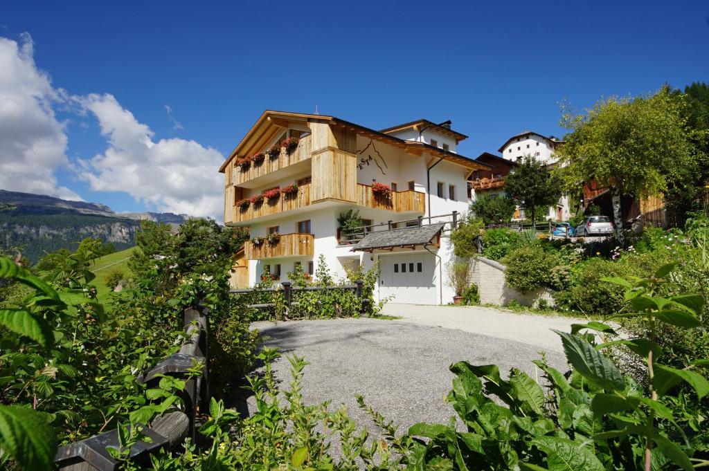 a large white building on a hill with bushes at Cresta in San Cassiano