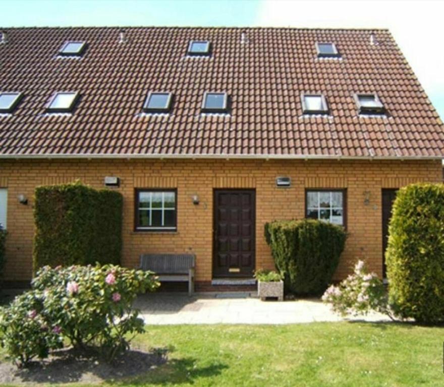 a brick house with a bench in a yard at Beiboot in Wangerland