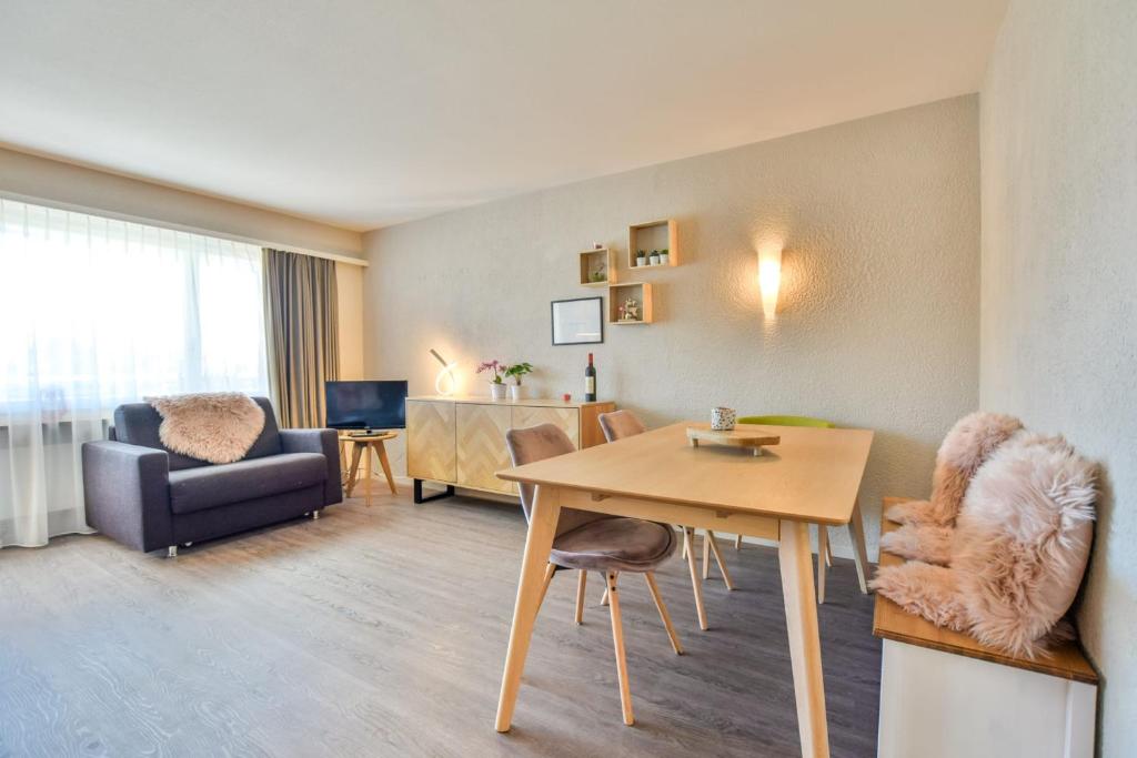 ein Wohnzimmer mit einem Tisch und Stühlen im Zimmer in der Unterkunft Rhodania 55 in Riederalp