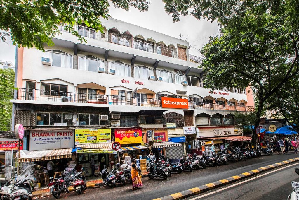 a building on the side of a street with motorcycles at FabHotel Spring Inn Kandivali in Mumbai