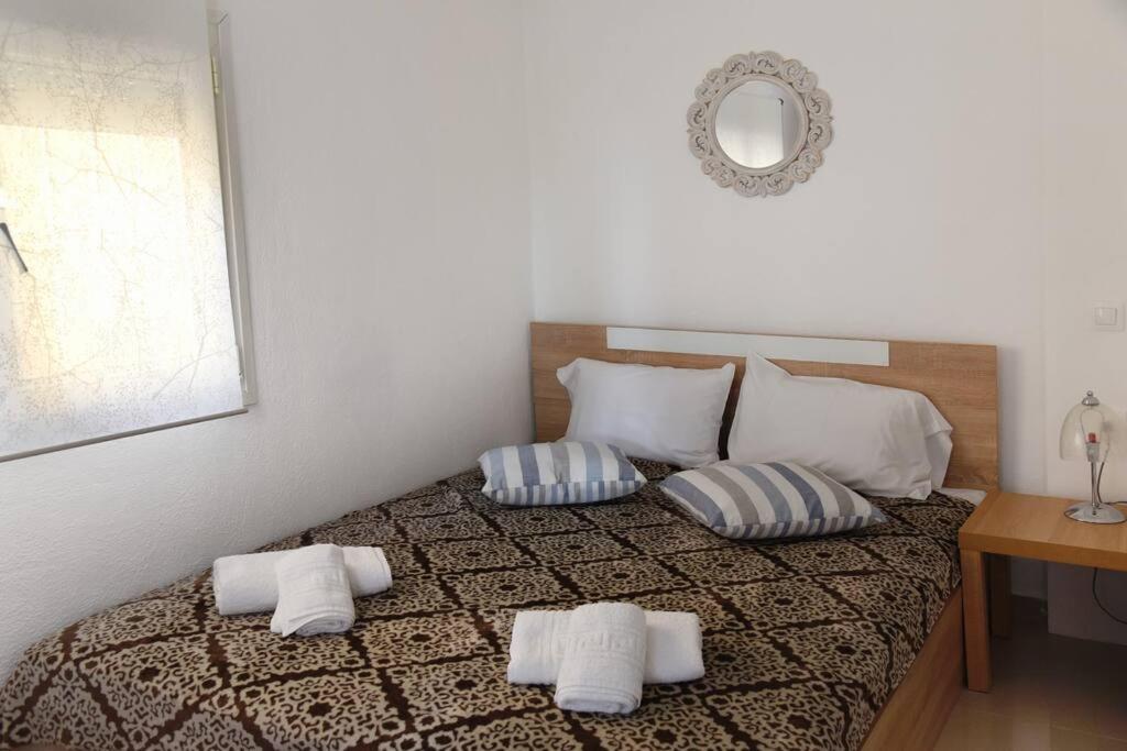 a bedroom with a bed with two pillows and a mirror at Summer Panorama ground floor studio in Epanomi