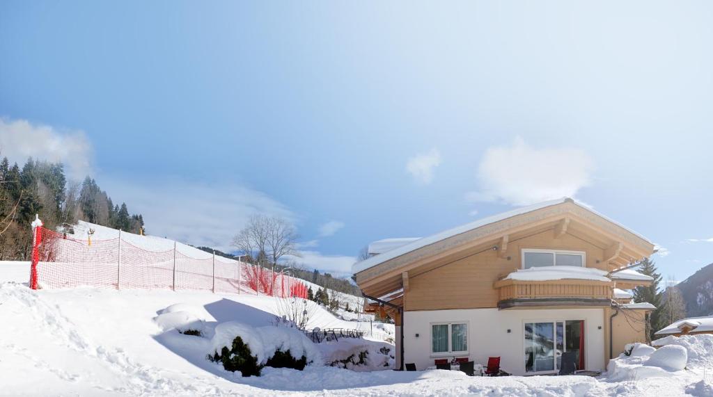 a house in the snow with a fence at Appartementhaus Casamarai in Saalbach Hinterglemm