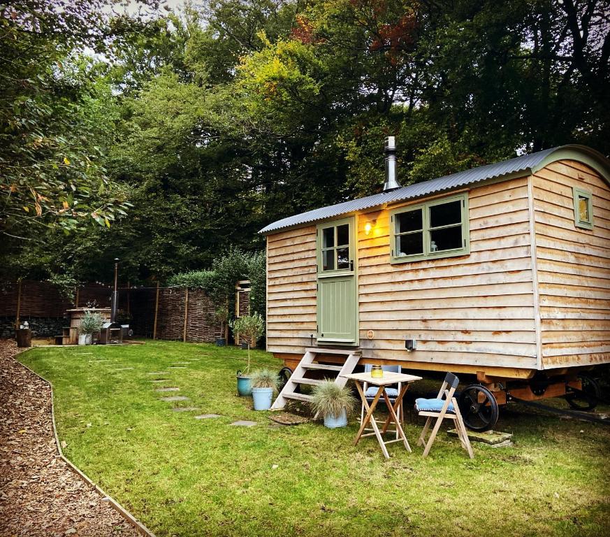 uma pequena casa num quintal com uma mesa e cadeiras em Oak + Stars Hideaway em Holmfirth