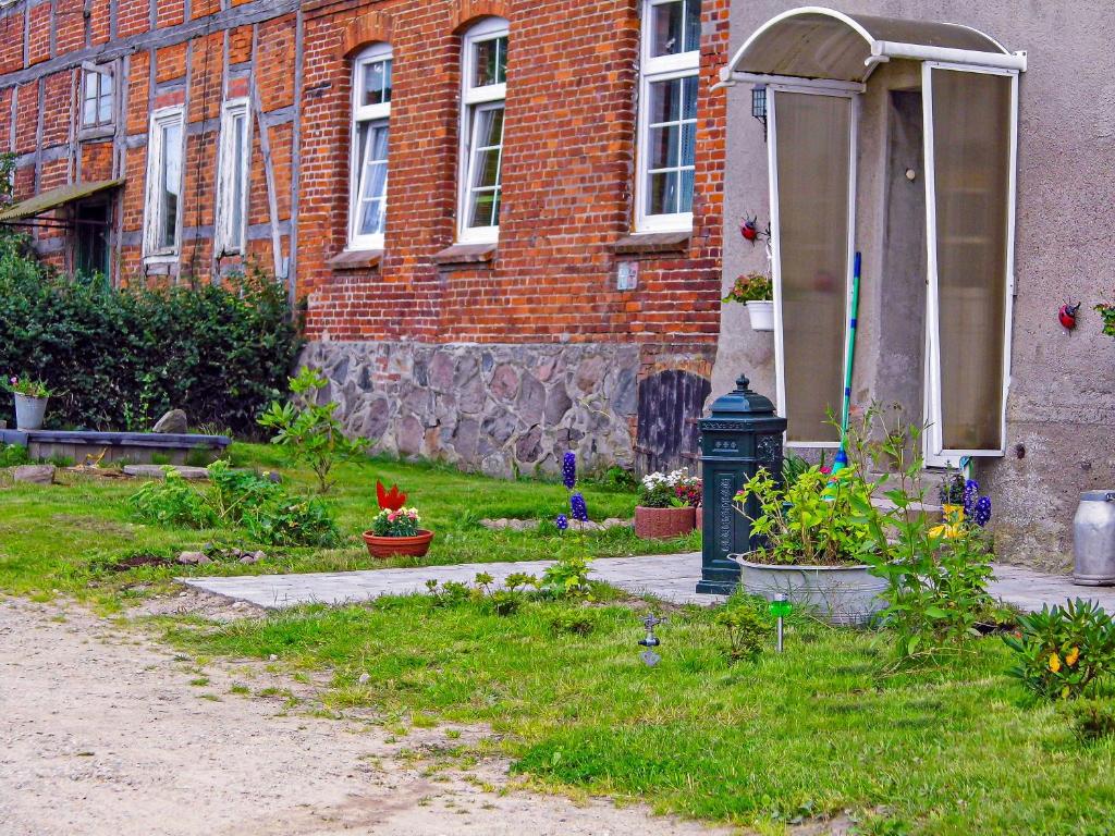 una casa con un patio con flores y una boca de incendios en Ferienwohnung Gluehwuermchen, en Barnin