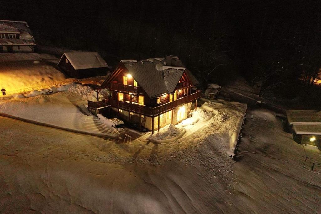 a house with lights on in the snow at night at Rodinný dům na Sluneční stráni in Dolni Dvur