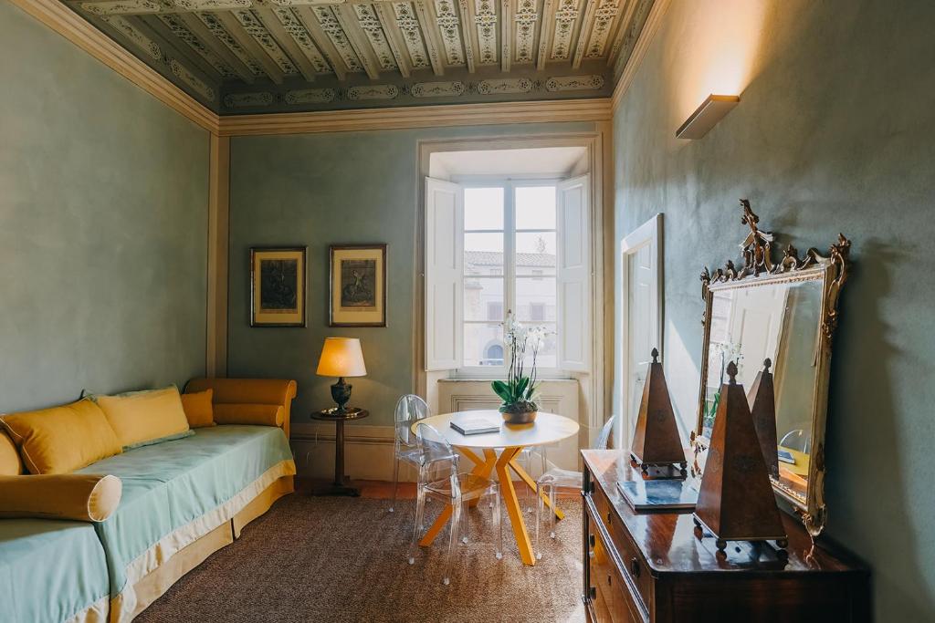 een woonkamer met een bank en een tafel bij Palazzo Feroci - Residenza d'epoca in Pisa